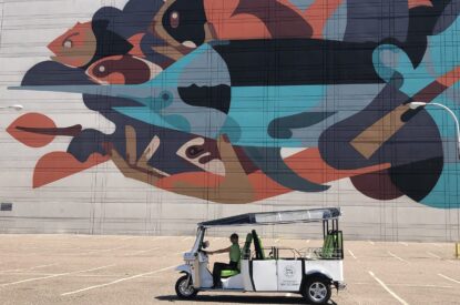 Tuk tuk in front of art mural